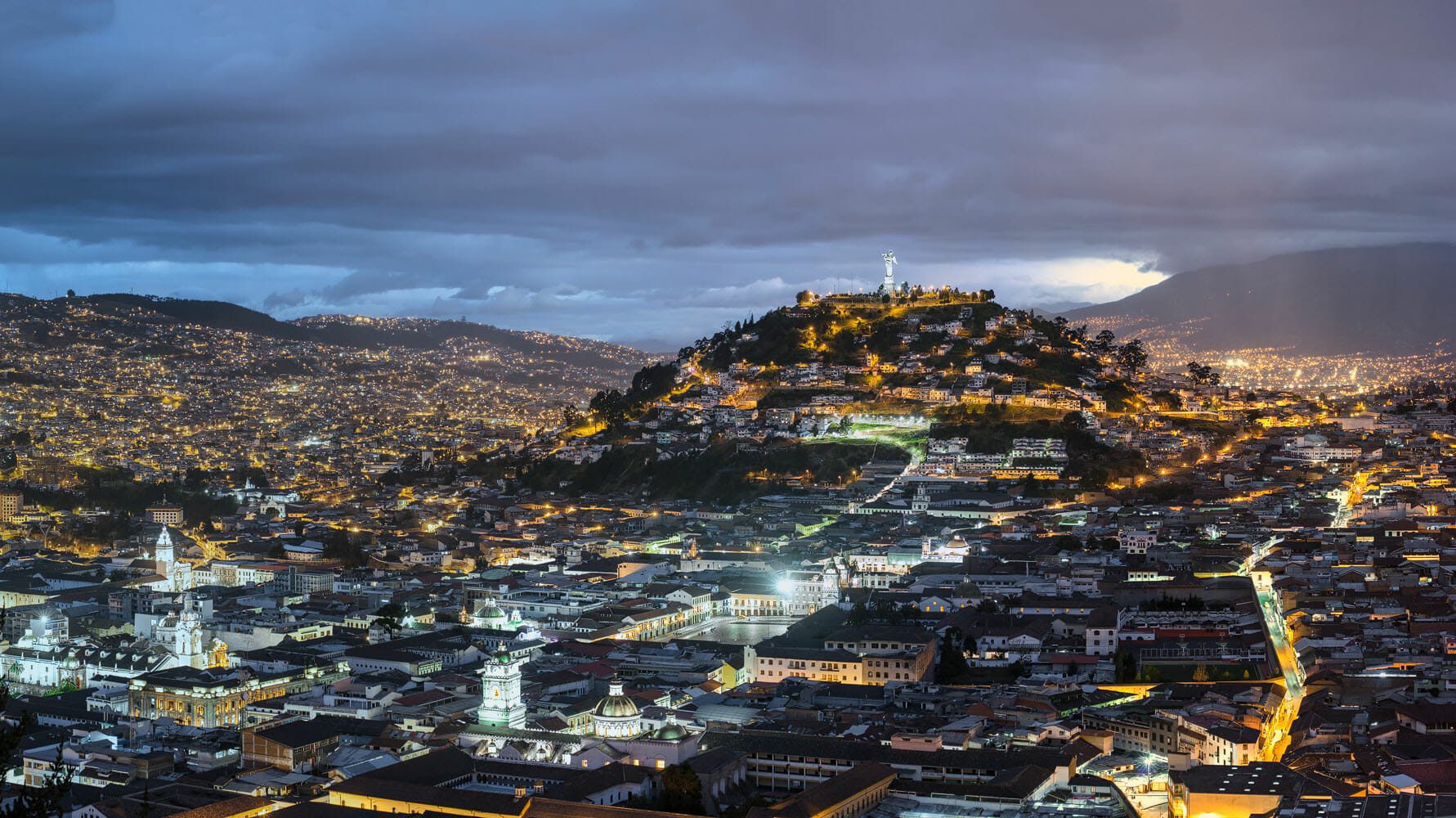 Panorama of the old town of Quito at blue hour dominated by the Panecillo and the Virgen de Quito statue
