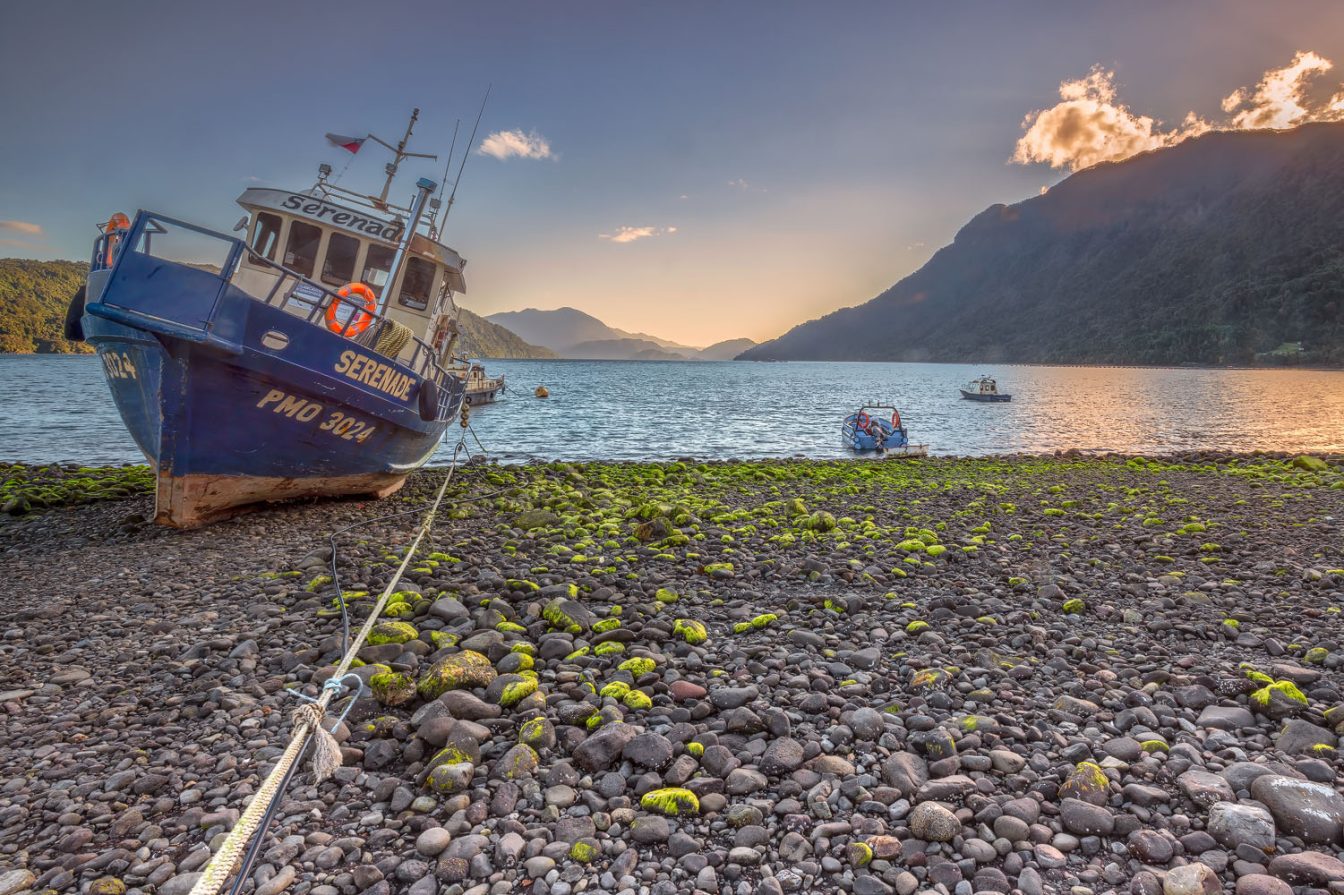 Golden hour photography of a fishing boat moored in the Hornopiren fjord