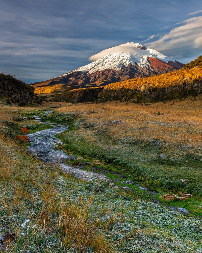 Mountain landscape photography of the Cotopaxi volcano illuminated by rising sun light on a cold and frosty early morning