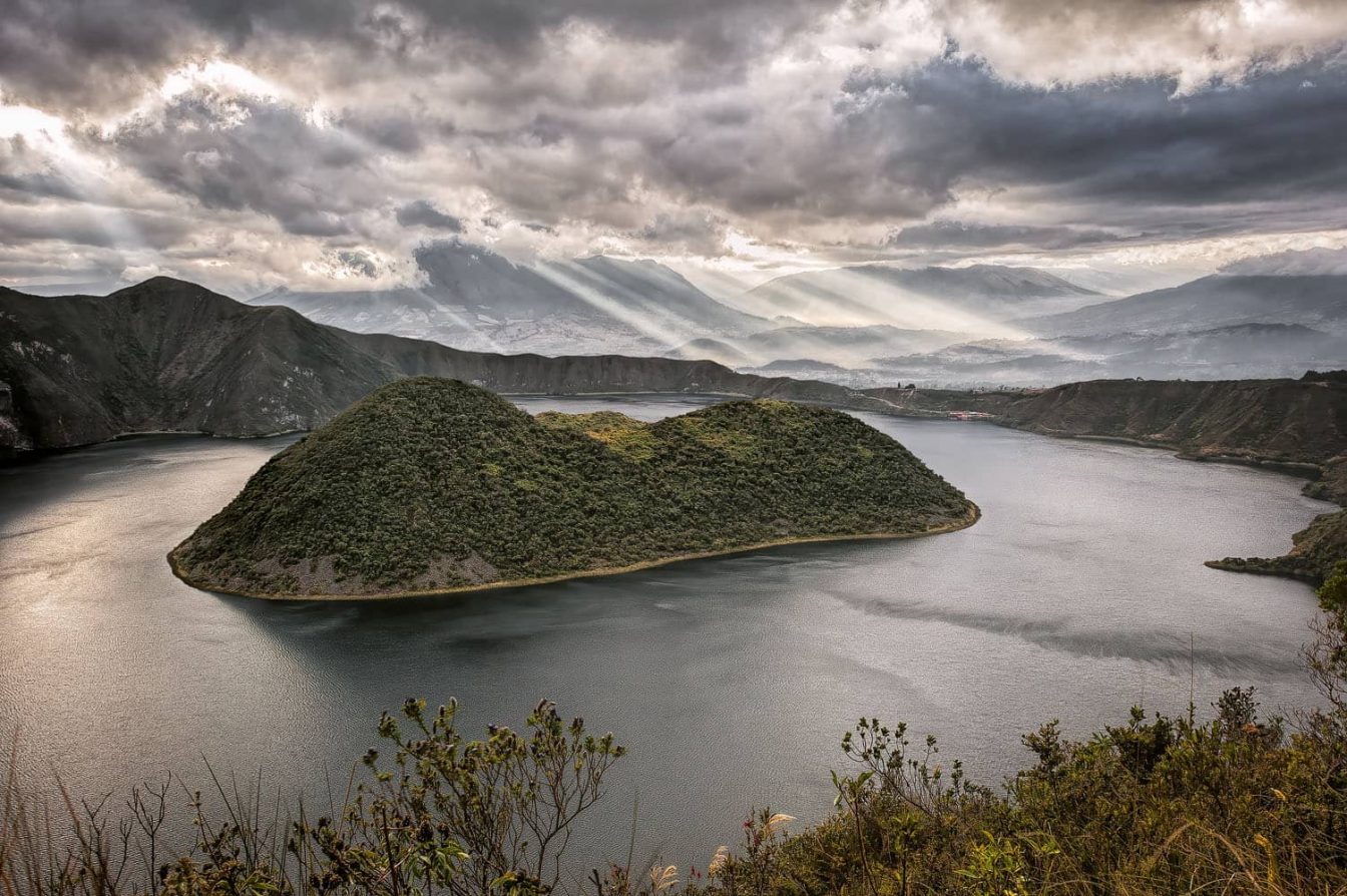 Photography of the volcano caldera and lake of Cuicocha at daybreak with beautiful sunrays