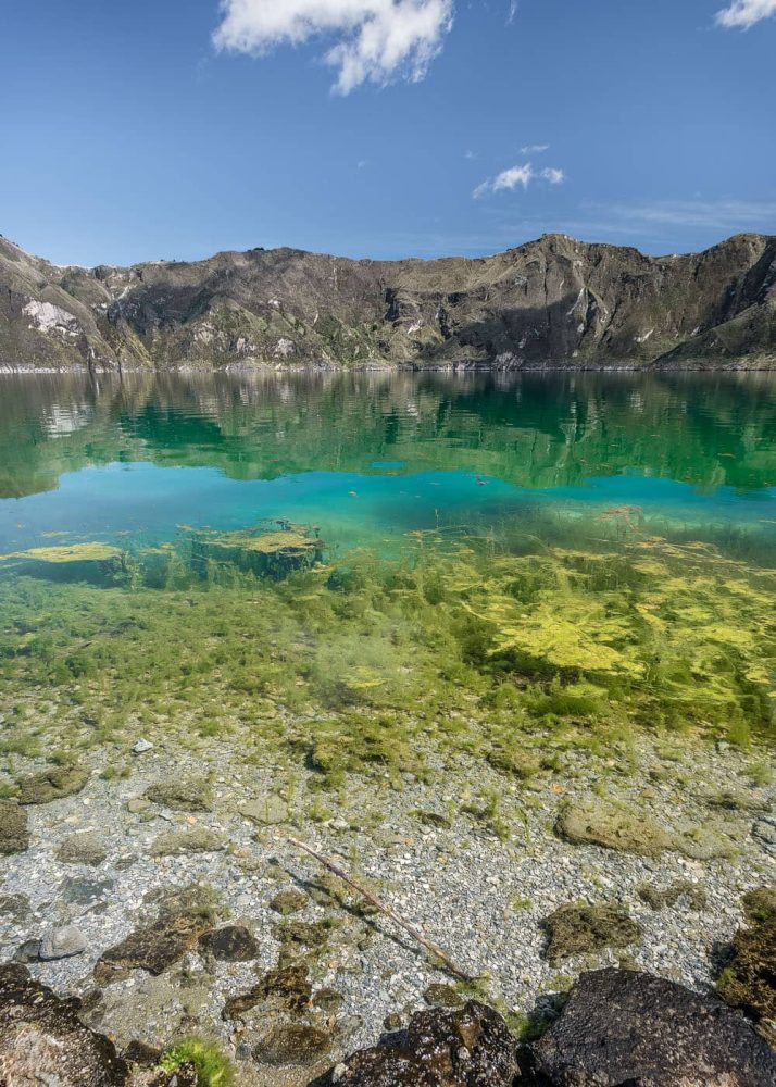 Image of the clear water, algae and emerald green lake of the Quilotoa crater
